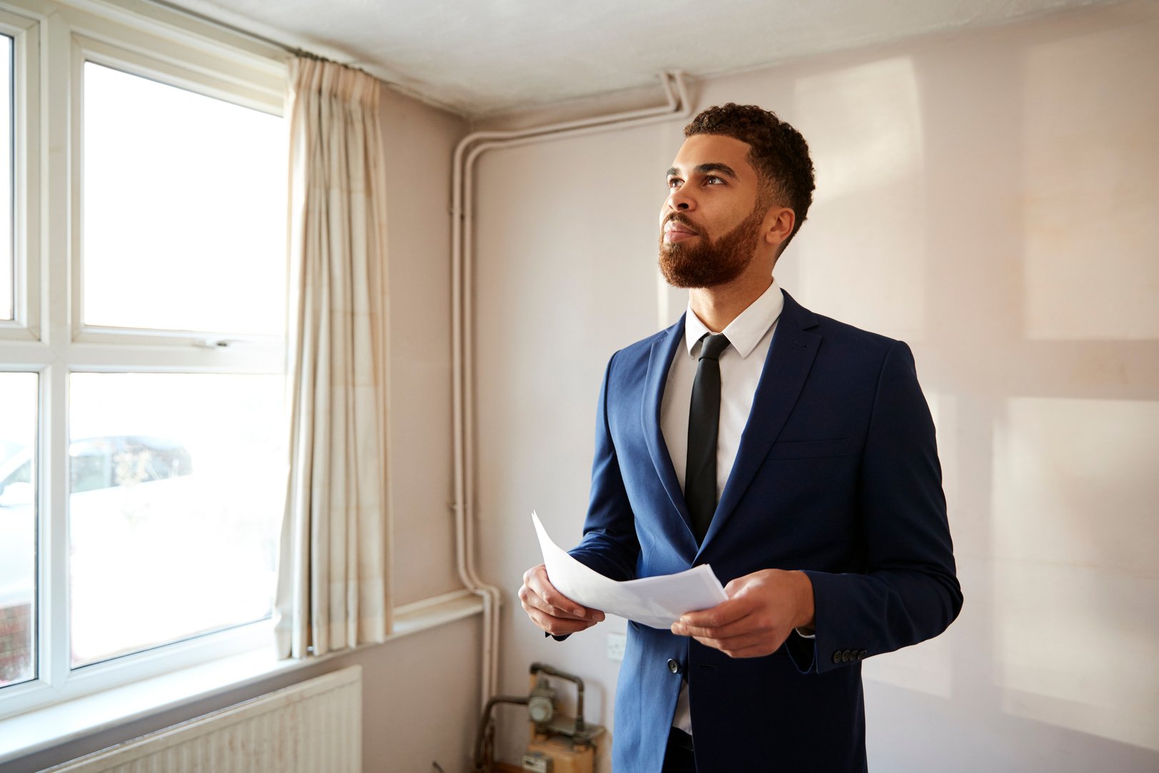 Male Realtor Looking at House Details in Property for Renovation